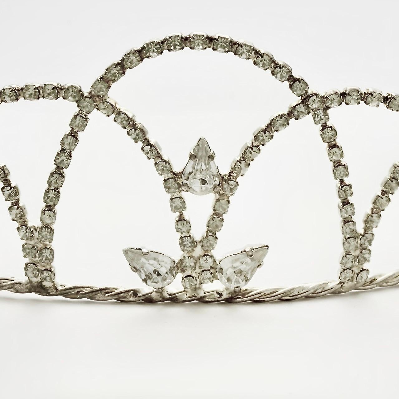 
Wonderful silver plated tiara with a rope twist band and featuring clear faceted rhinestones. Measuring height at the front 4.7 cm / 1.85 inches, the rhinestones are all prong set. The tiara is in very good condition, there is very little wear to