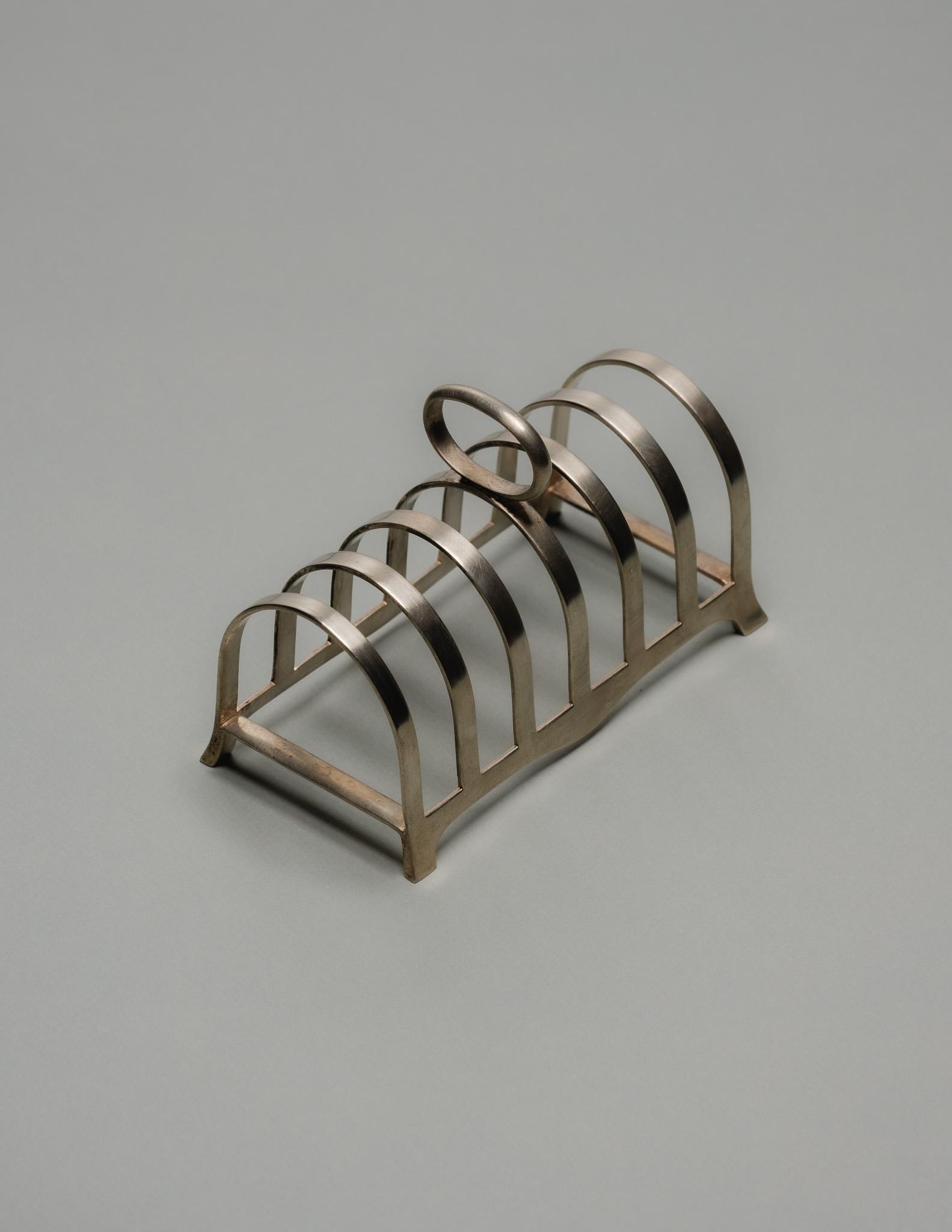 Silver-Plated Toast Rack with Helical Structure, 1950s.
Resting on four ball feet, this piece is typical of 1950s English design, combining functionality with modernist lines.

DV4744