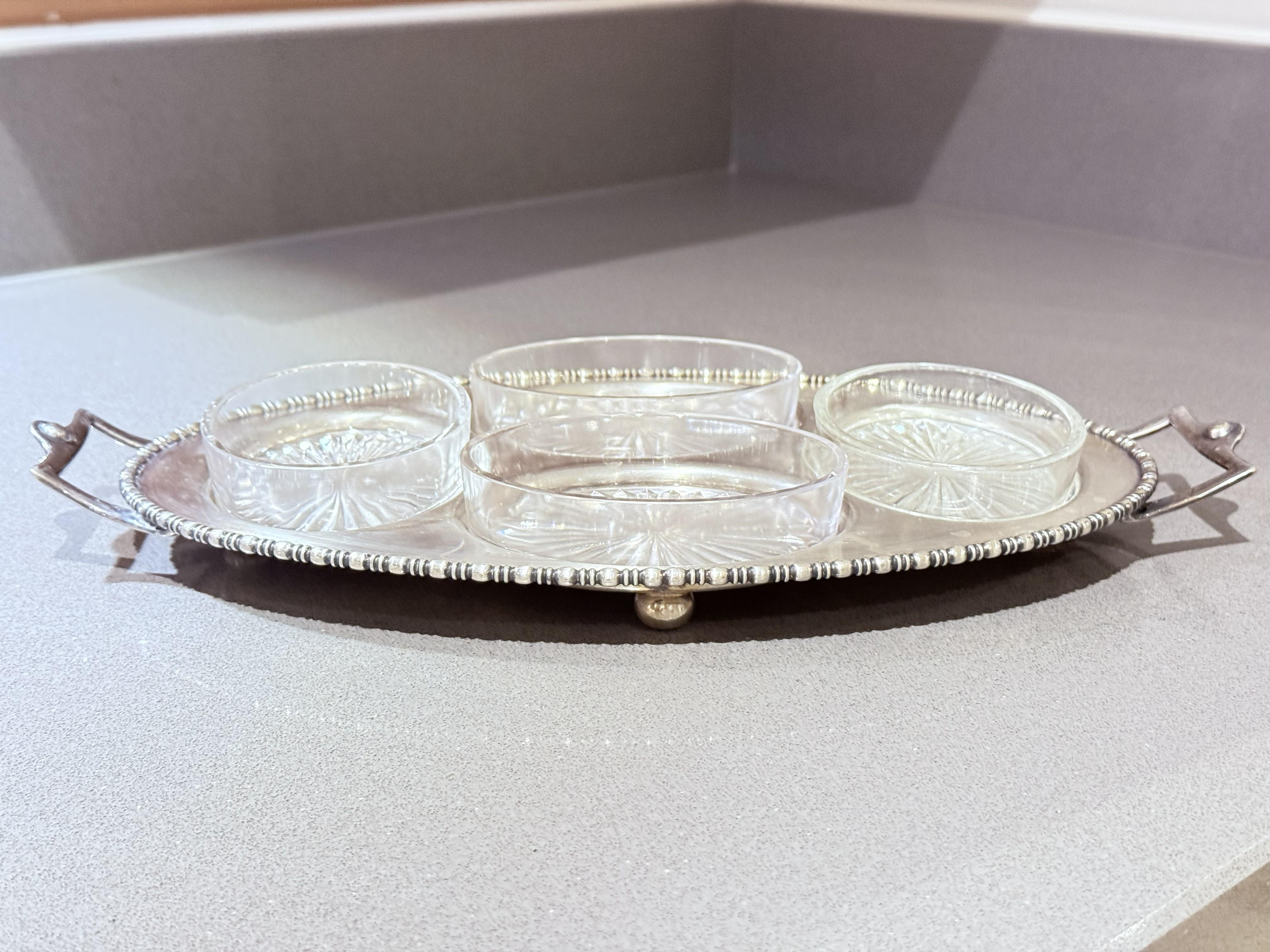 Vassoio placcato in argento con quattro piatti in vetro tagliato, set da intrattenimento vintage
Un raffinato vassoio da portata d'epoca placcato in argento completo di quattro piatti originali in vetro tagliato: questo elegante set è un esempio di