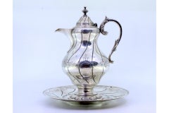 Silver-plated wine jug with engravings, relief handle, and knobbed lid