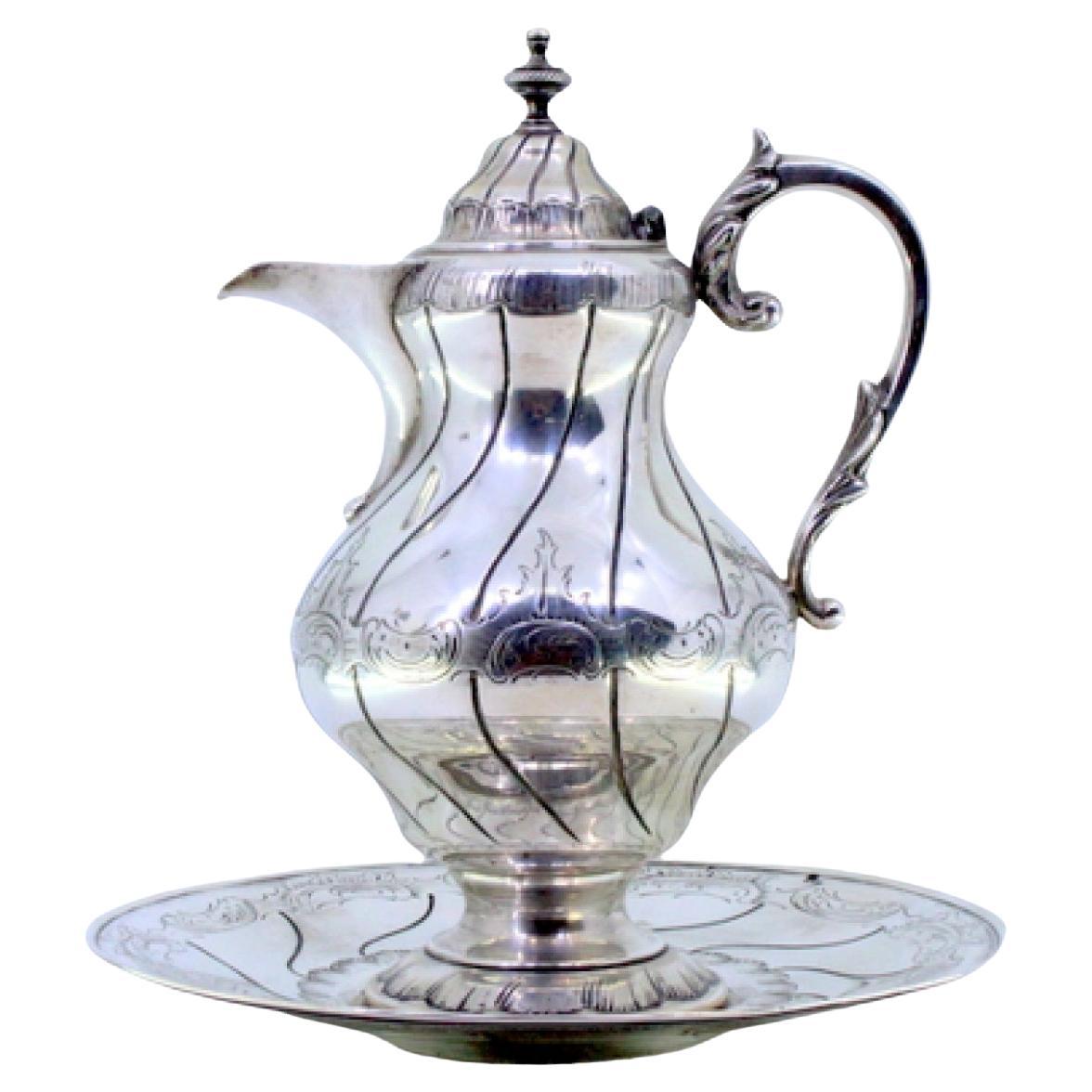Silver-plated wine jug with engravings, relief handle, and knobbed lid