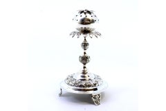 Silver poppy-shaped toothpick holder on three raised feet