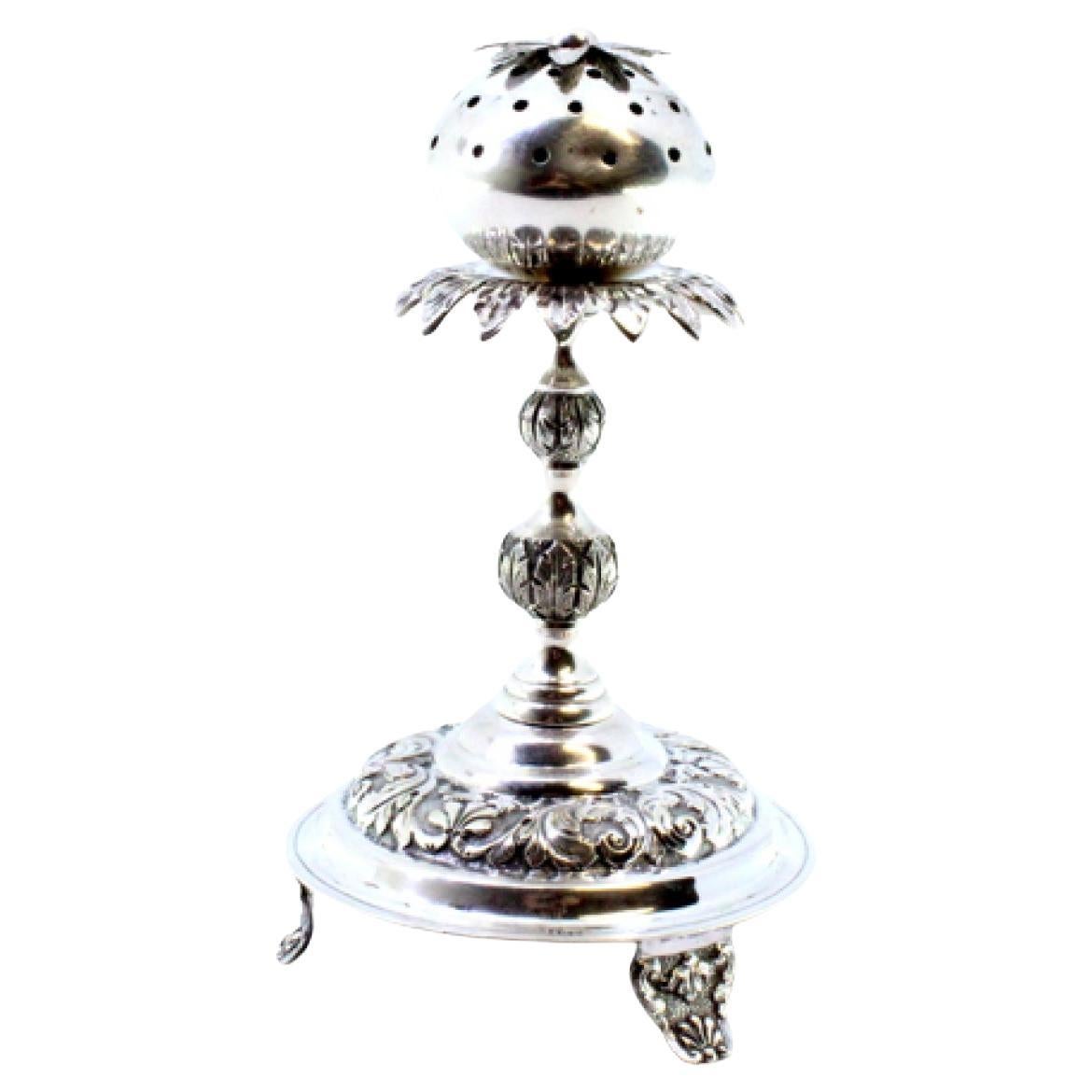 Silver poppy-shaped toothpick holder on three raised feet