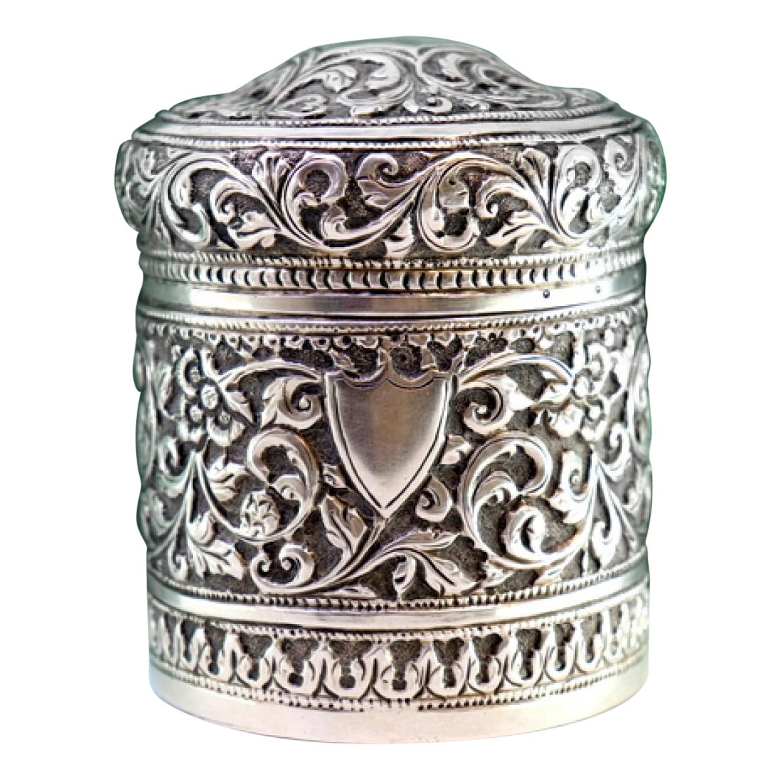 Pot en argent avec reliefs floraux et plaque de monogramme sur le couvercle amovible.