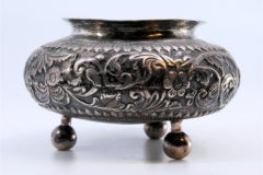 Silver pot with garland and floral reliefs on three spherical feet