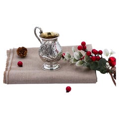 Silver pot with raised floral motifs, monogram card, and question-mark handle