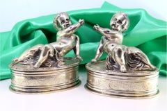 Silver puttis in perfect elliptical shapes with a surrounding frieze