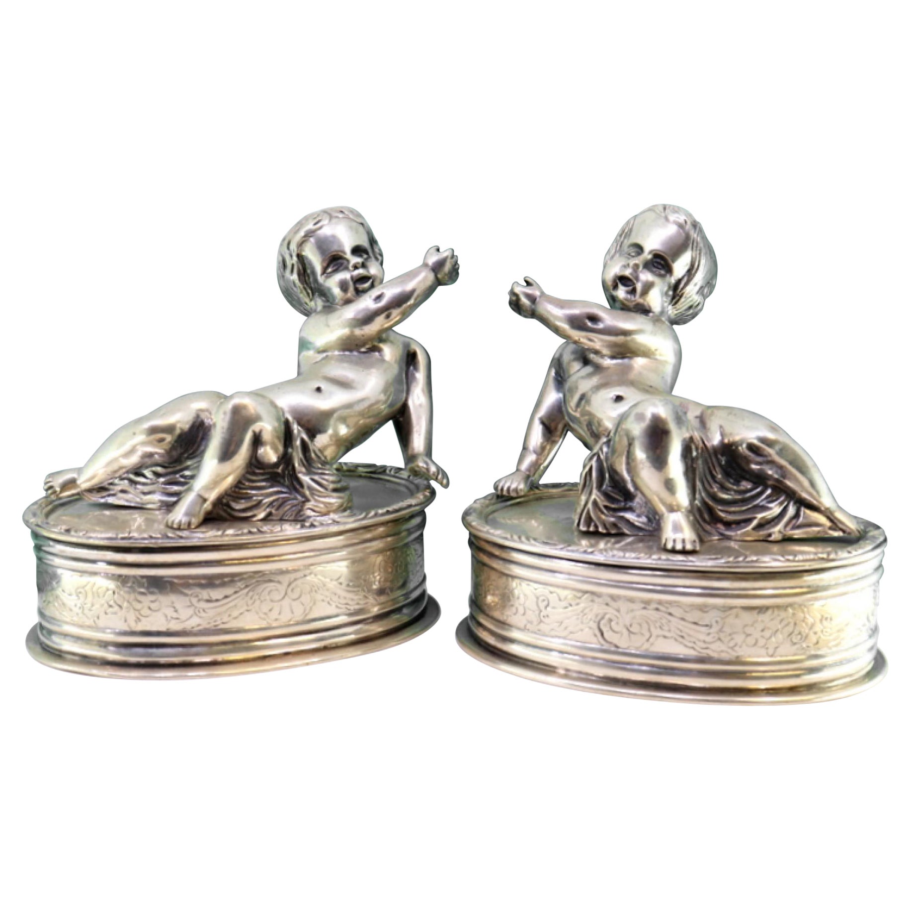 Silver puttis in perfect elliptical shapes with a surrounding frieze