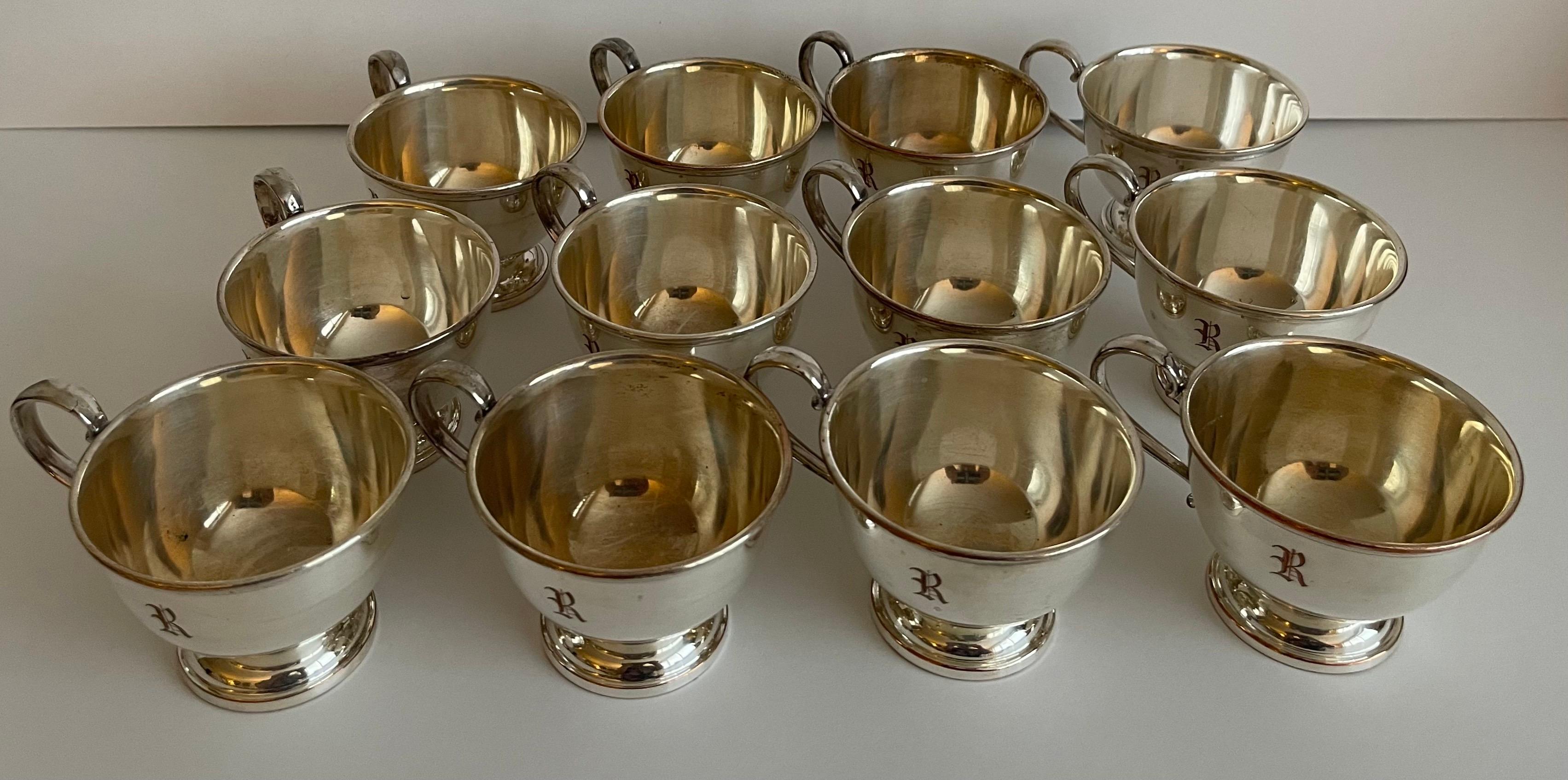 Satz von 12 versilberten Punschtassen aus den 1950er Jahren. 
Einzelnes R-Monogramm auf jeder Tasse,
Auf der Unterseite gestempelt EPC (electroplated copper). 

Die Tassen wurden neu professionell auf Hochglanz poliert, weisen aber insgesamt