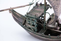 Silver rabelo boat with hammered sail, barrels and removable oars