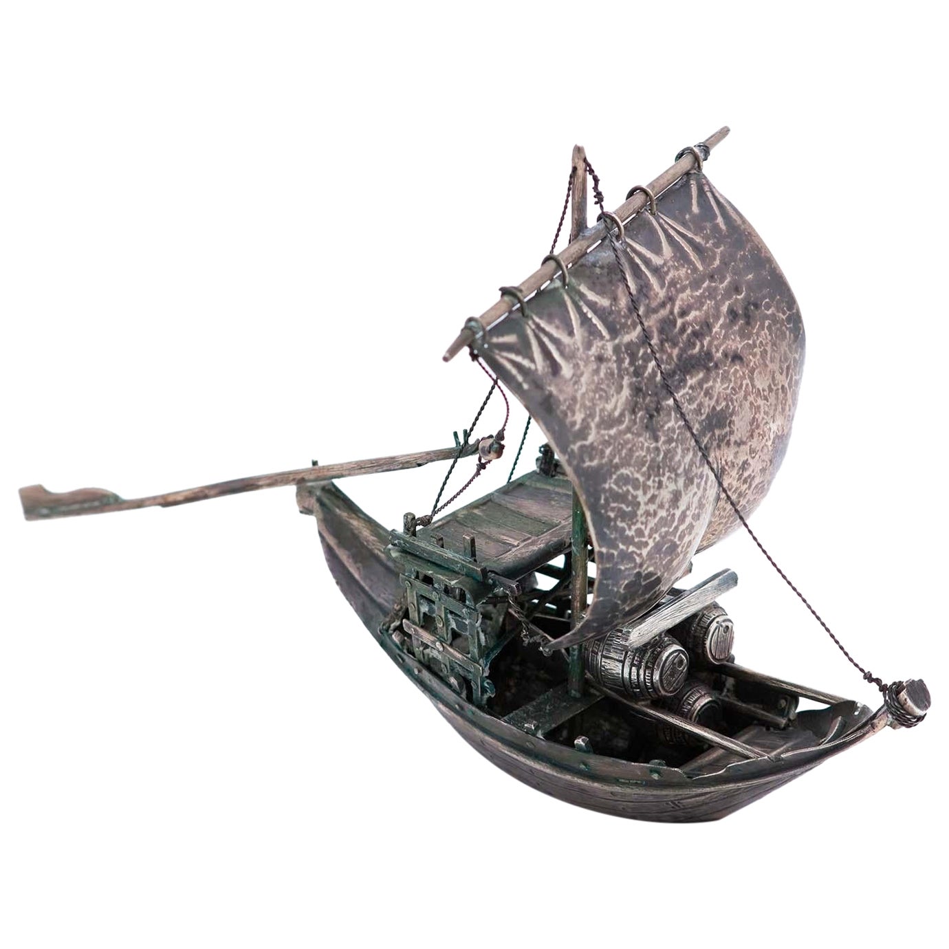 Silver rabelo boat with hammered sail, barrels and removable oars