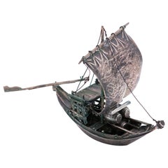 Silver rabelo boat with hammered sail, barrels and removable oars