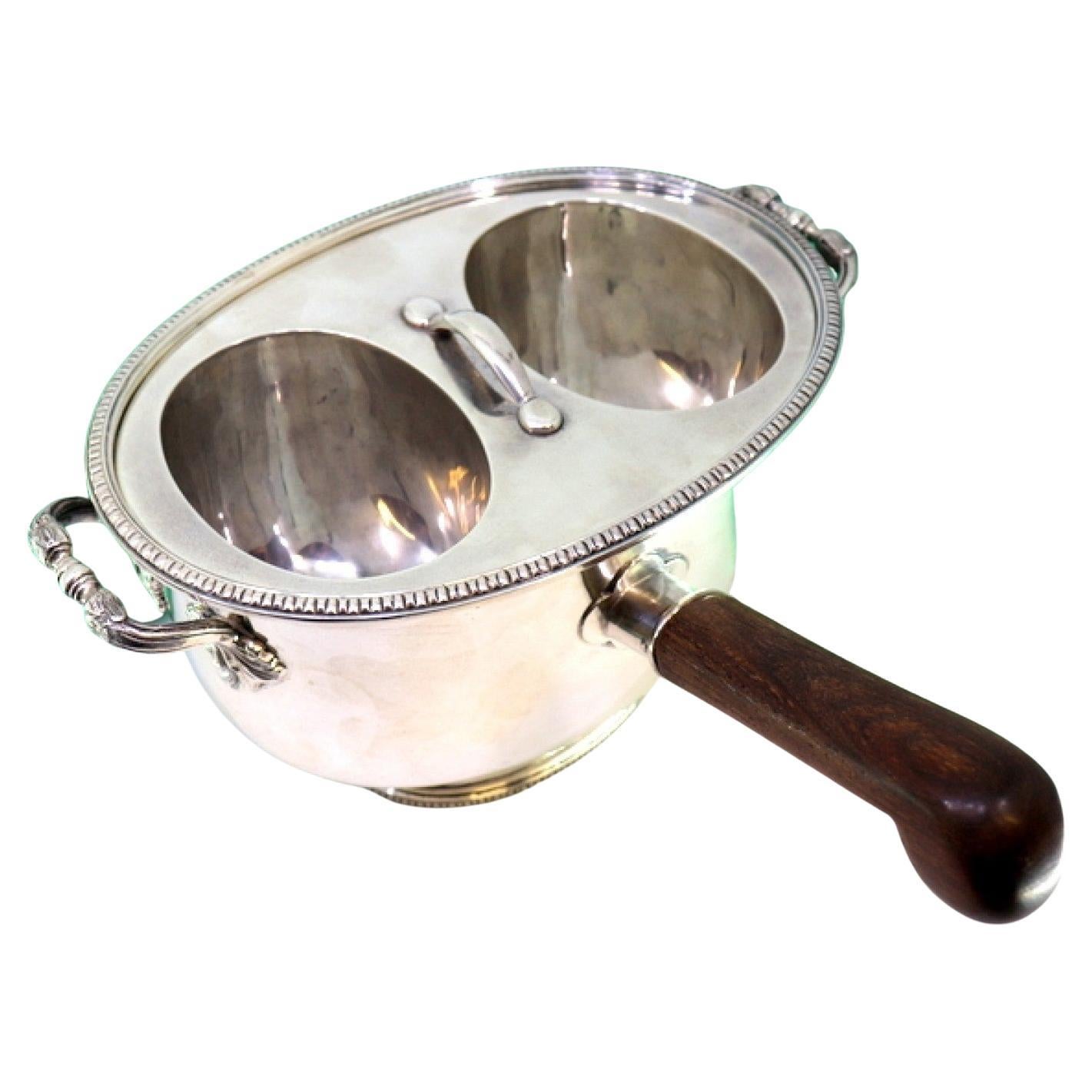Silver rechaud with twin tanks, raised friezes 
wooden handle