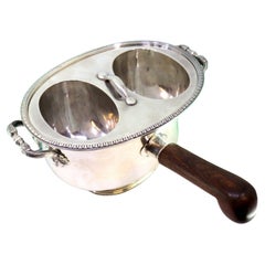 Silver rechaud with twin tanks, raised friezes 
wooden handle