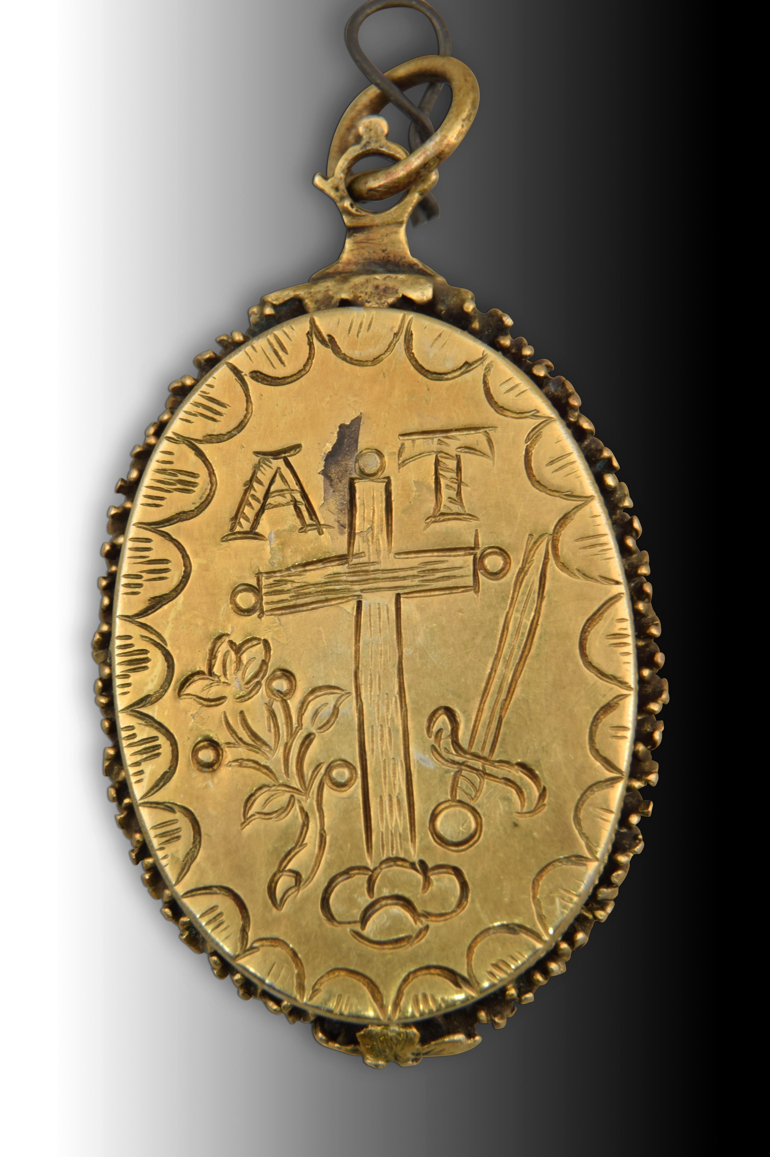 Reliquary with saint and shield of the Inquisition. gilt silver Spain, 17th century. 
Devotional pendant and locket featuring a gilt-silver border decorated with plant elements, reeds, a fine torso cord, and simplified elements. Inside, it presents