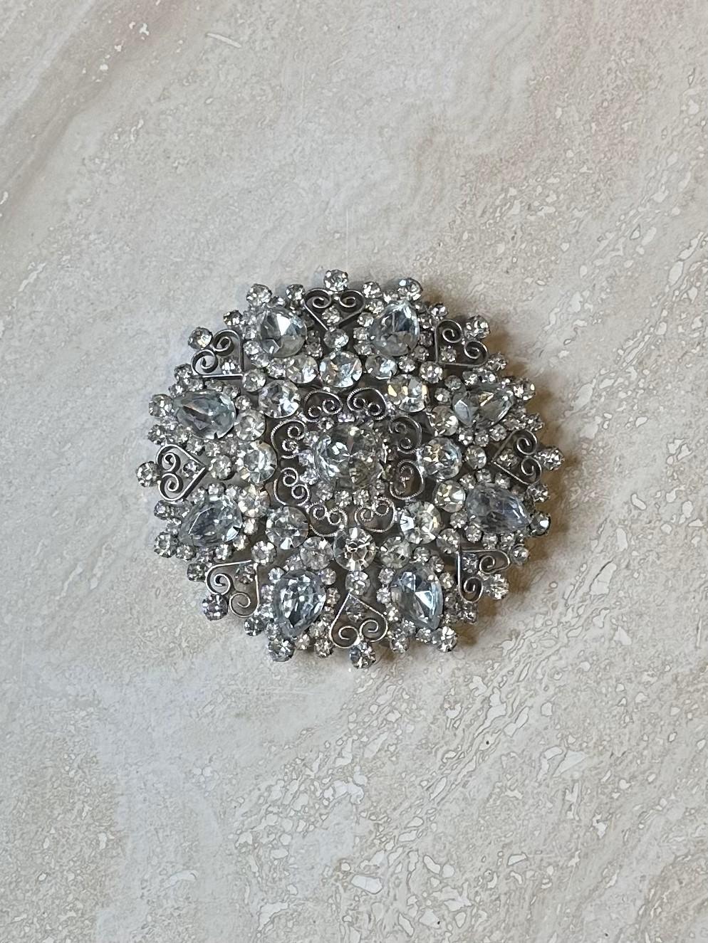 Eine silberne Gürtelschnalle mit Strasssteinen ist ein glamouröses und vielseitiges Accessoire, das jedem Gürtel oder Outfit einen Hauch von Glanz und Raffinesse verleihen kann. Ob ein schlichter Ledergürtel oder ein breiter Bund im Boho-Chic, die