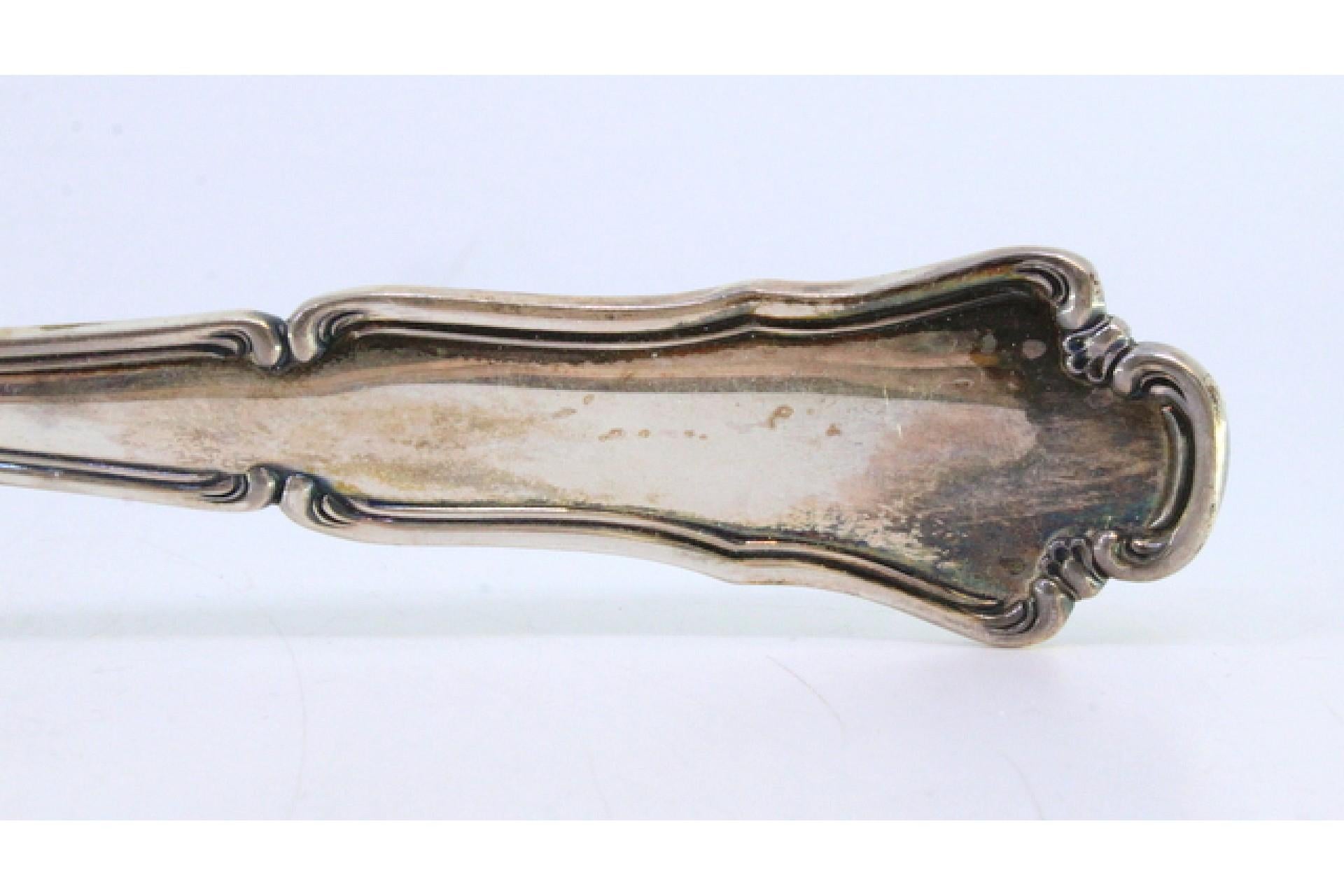 Silver rice and serving spoon with a long, scalloped handle siglo XX en venta