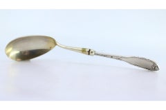 Silver rice and serving spoon with grooves and reliefs on the handle