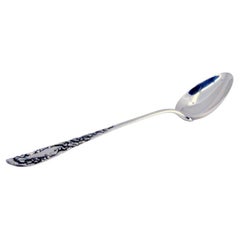 Silver rice and serving spoon with reliefs and a medallion on the handle