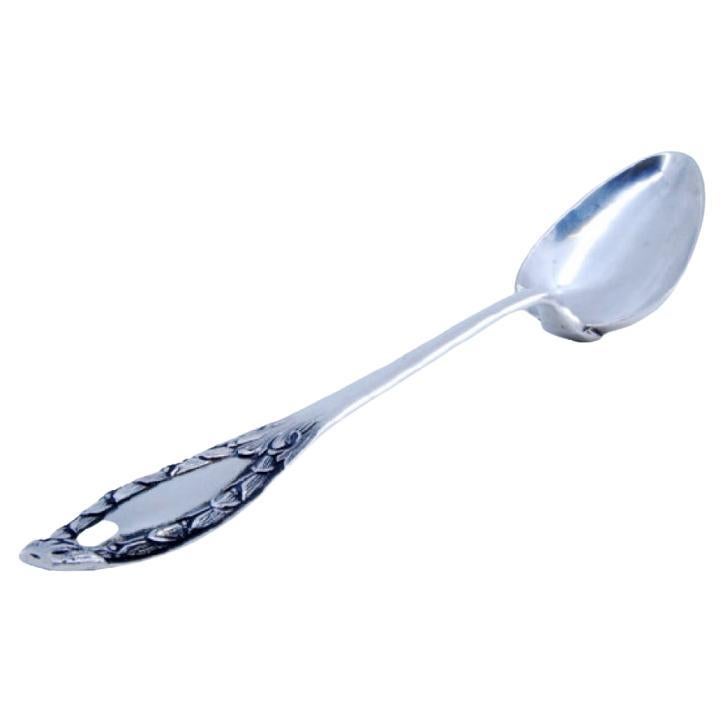 Silver rice and serving spoon with reliefs and a medallion on the handle For Sale
