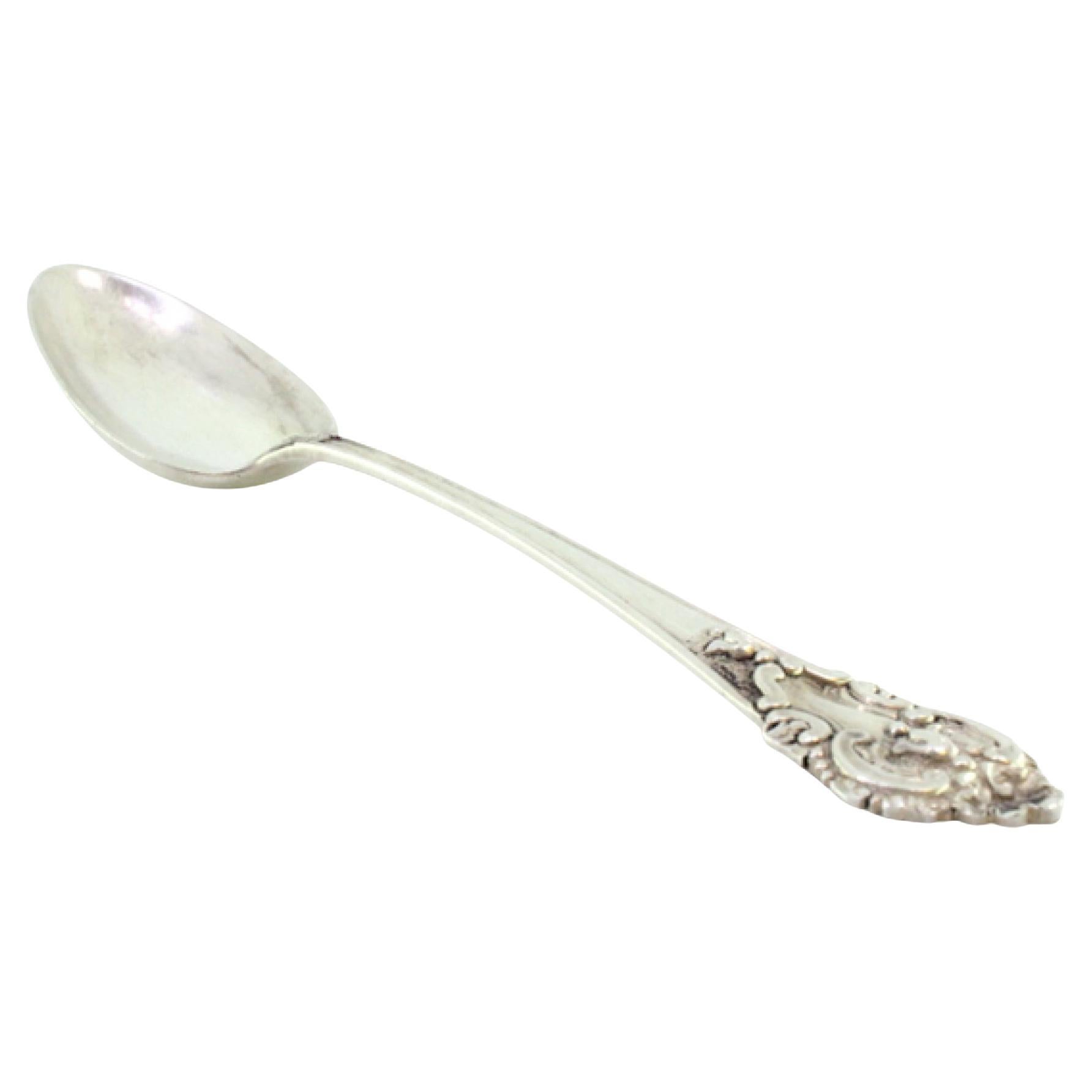 Silver rice and serving spoon with shell-shaped trim and reliefs on the handle