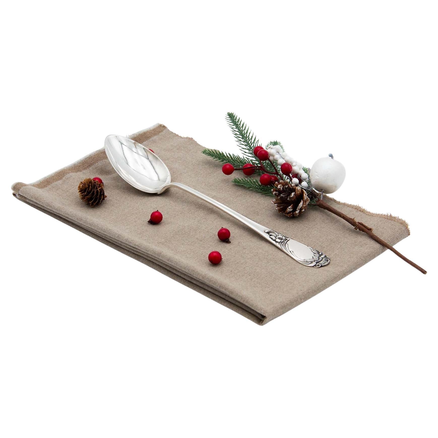 Silver rice and serving spoons with relief handles around monogram