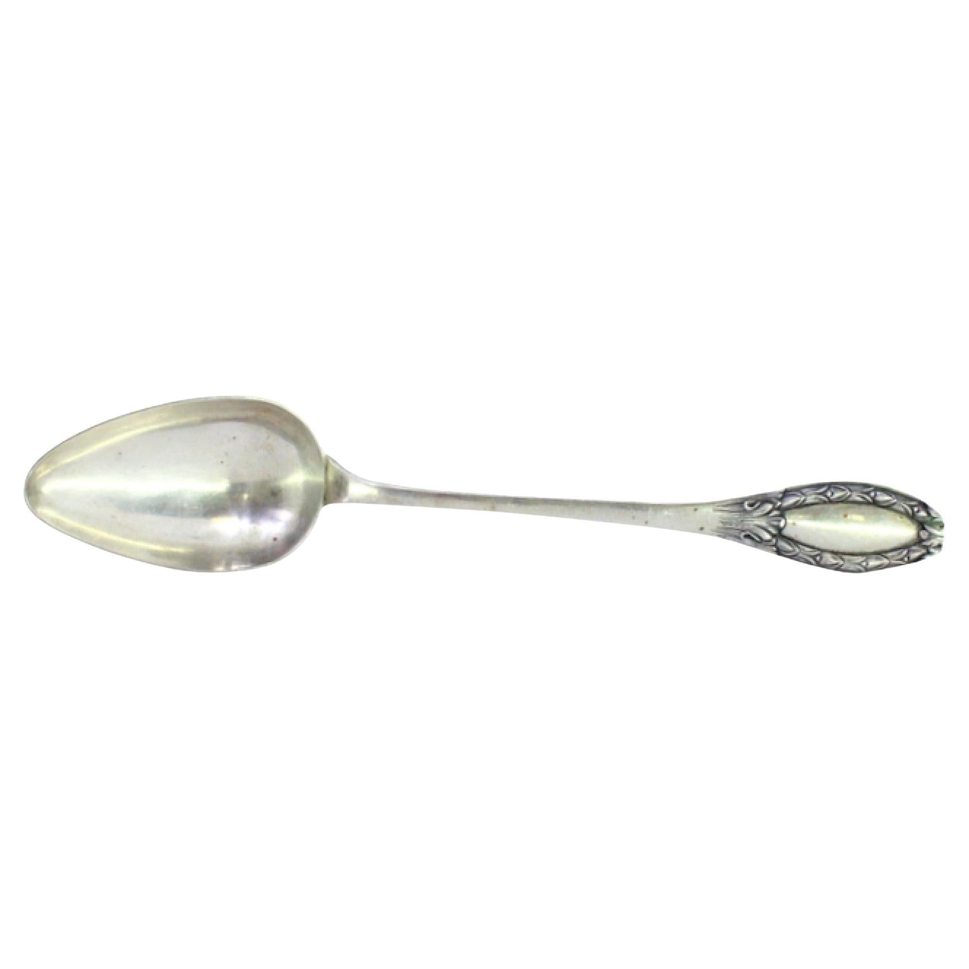 Silver rice
serving spoon w/ reliefs on the handle surrounding a monogram card