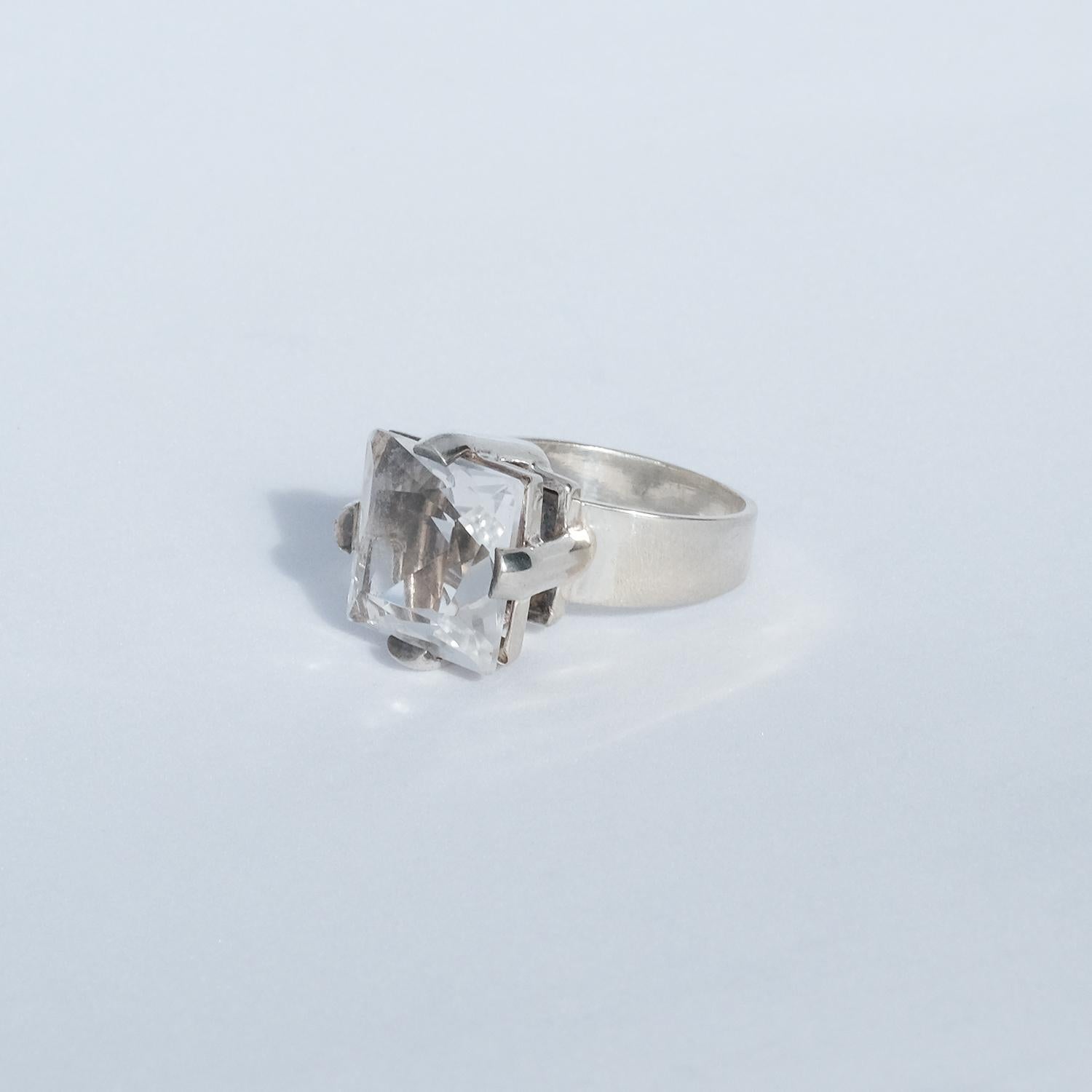 Dieser Ring aus Silber und Bergkristall hat einen großen quadratischen Bergkristall mit Facettenschliff.   

Er passt sowohl in ein alltägliches als auch in ein eher festliches Umfeld.