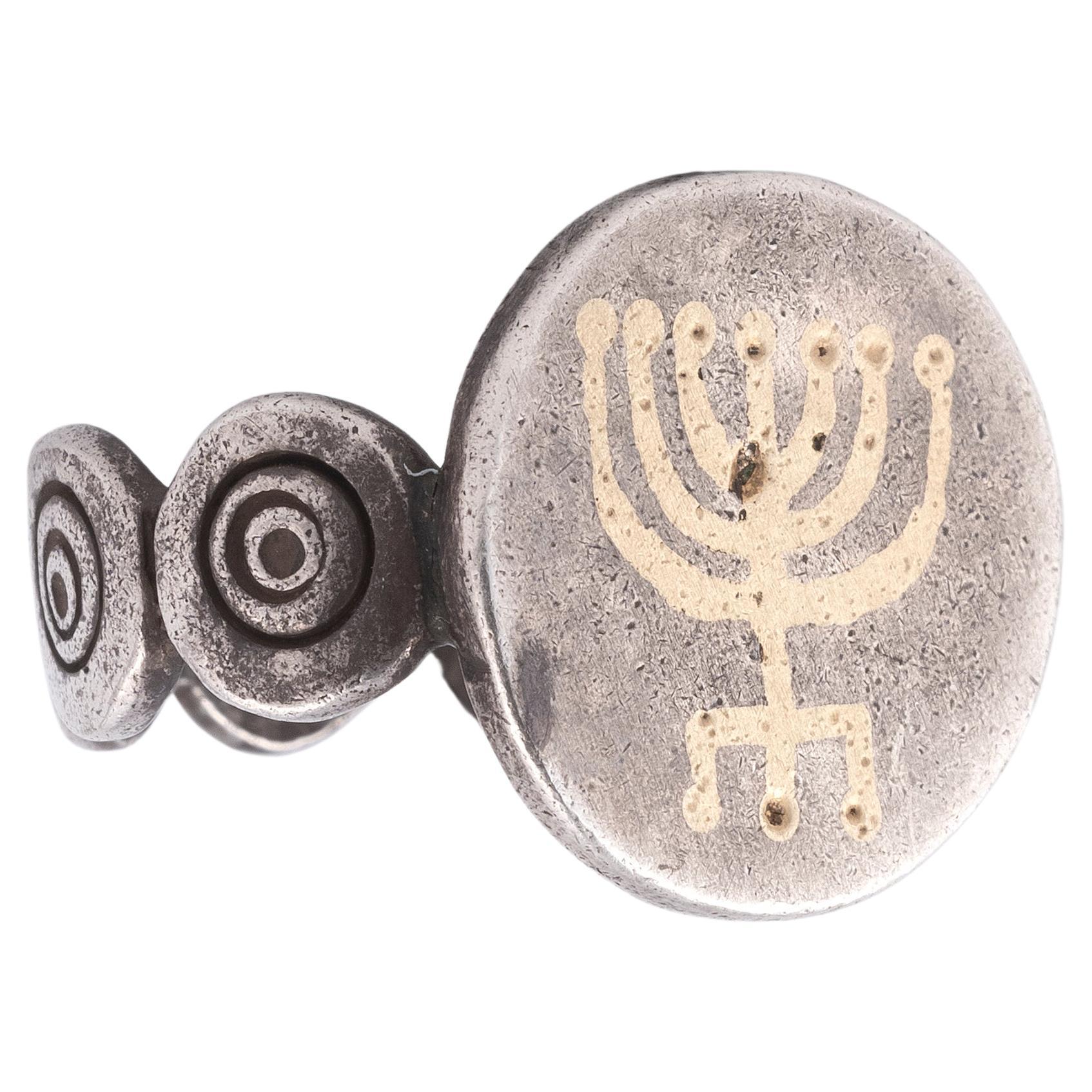 Silver ring with a gold coloured jewish menorah.
Period: 18th century
Dimensions: 1,7 mm, 9,2 gr.
Condition: good
Size 7 3/4