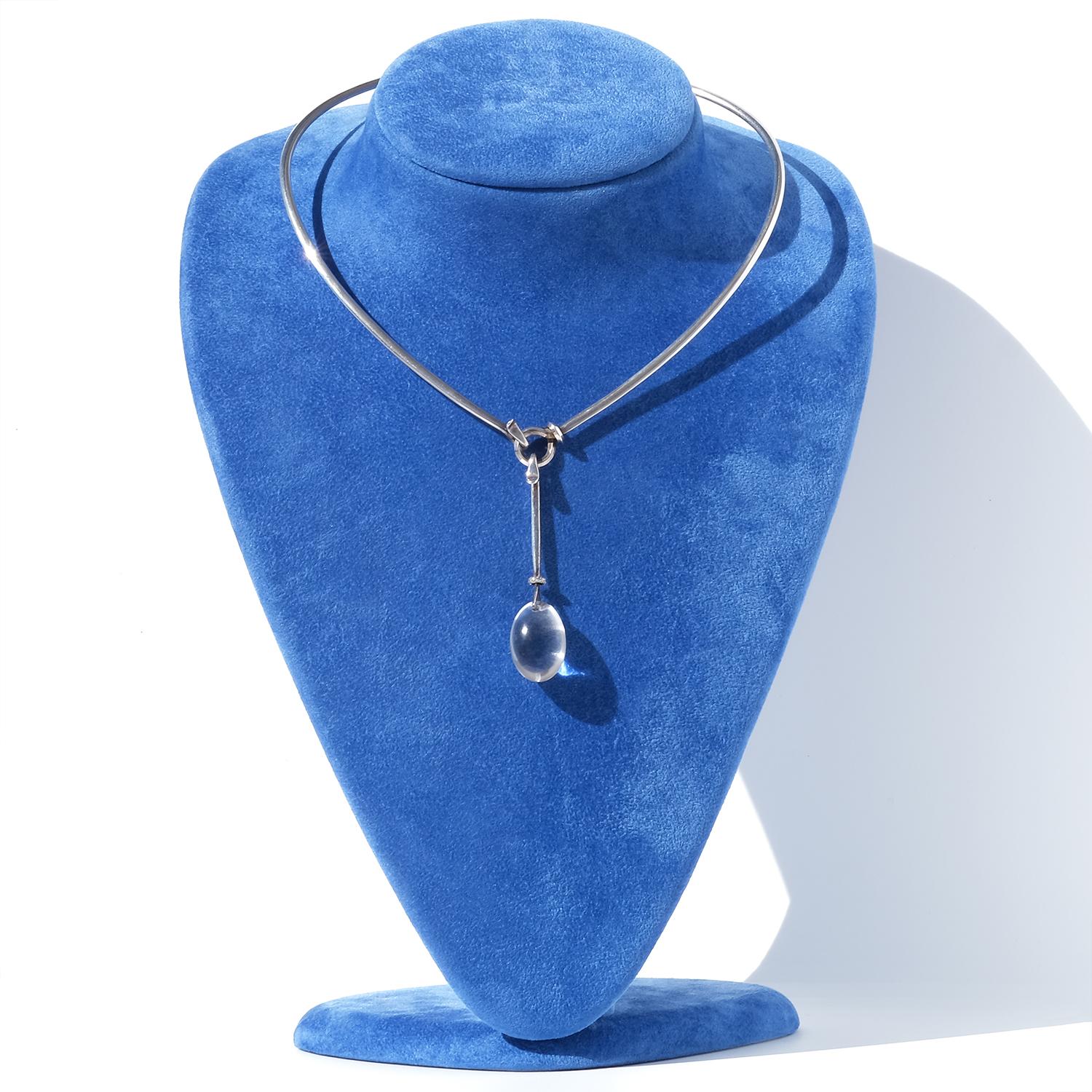 Questo anello da collo in argento vintage ha un design elegante e scultoreo, con una forma strutturata e leggermente triangolare che si adatta con grazia al collo. Si chiude sul davanti con un semplice gancio, diventando parte integrante del design.