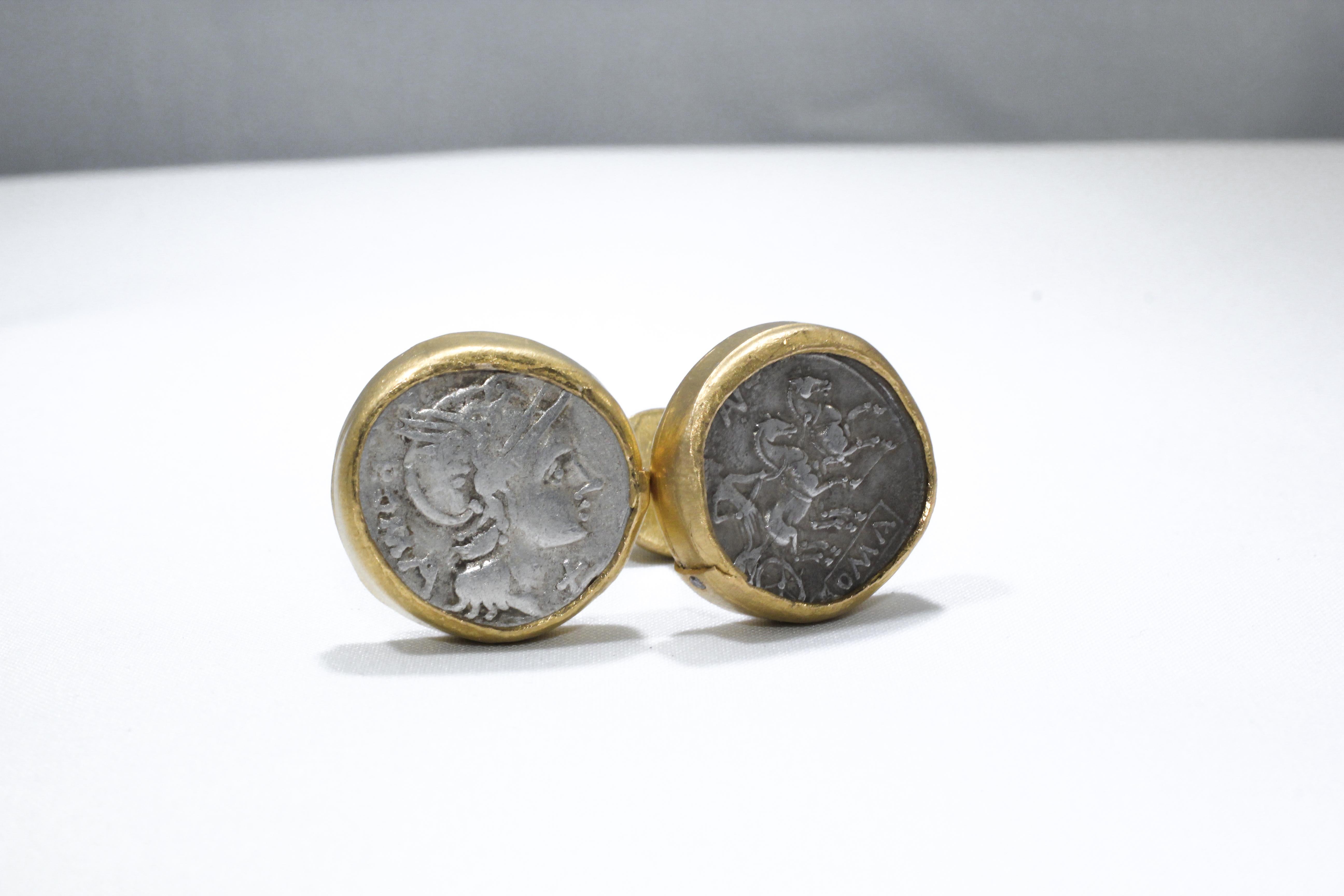 Manschettenknöpfe mit Münzen. Antike römische Münzen aus dem 2. Jh. v. Chr., eingefasst in 21-karätige Goldfassungen, mit kleinen Diamantakzenten. Zeitgenössisches Schmuckdesign von AB Jewelry NYC.

Diese kühnen und maskulinen Manschettenknöpfe, die