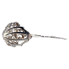 Silver salad or bread tongs with a cutout on the shell and relief on the stems