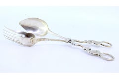 Silver salad tongs with spoon and fork embossed on the handles