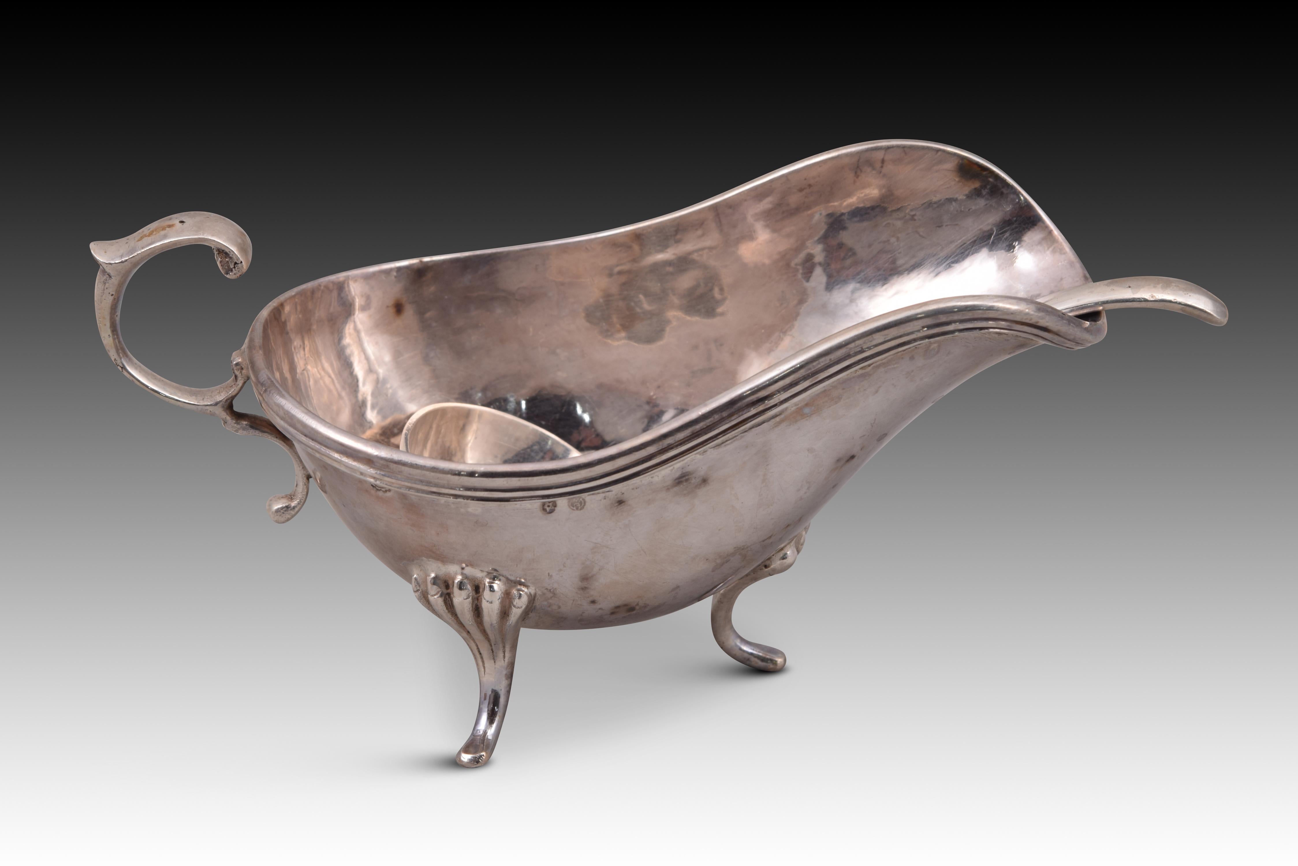Sauceboat with saucepan. Silver. Manuel Garrido for Platerías López. Spain, Madrid, 20th century. 
With contrast markings. 
Silver sauce boat in its color with an oval shape and finished in a spout, which has a ce shaped handle and three legs
