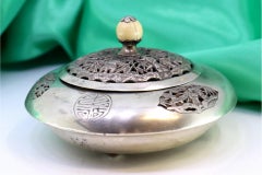 Boîte en argent en forme de soucoupe avec découpes orientales, frises grecques et bouton en ivoire.