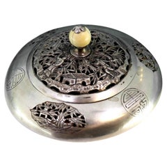 Scatola d'argento a forma di piattino con ritagli orientali, fregi greci e pomello in avorio Scatola d'argento a forma di piattino con ritagli orientali, fregi greci e pomello in avorio