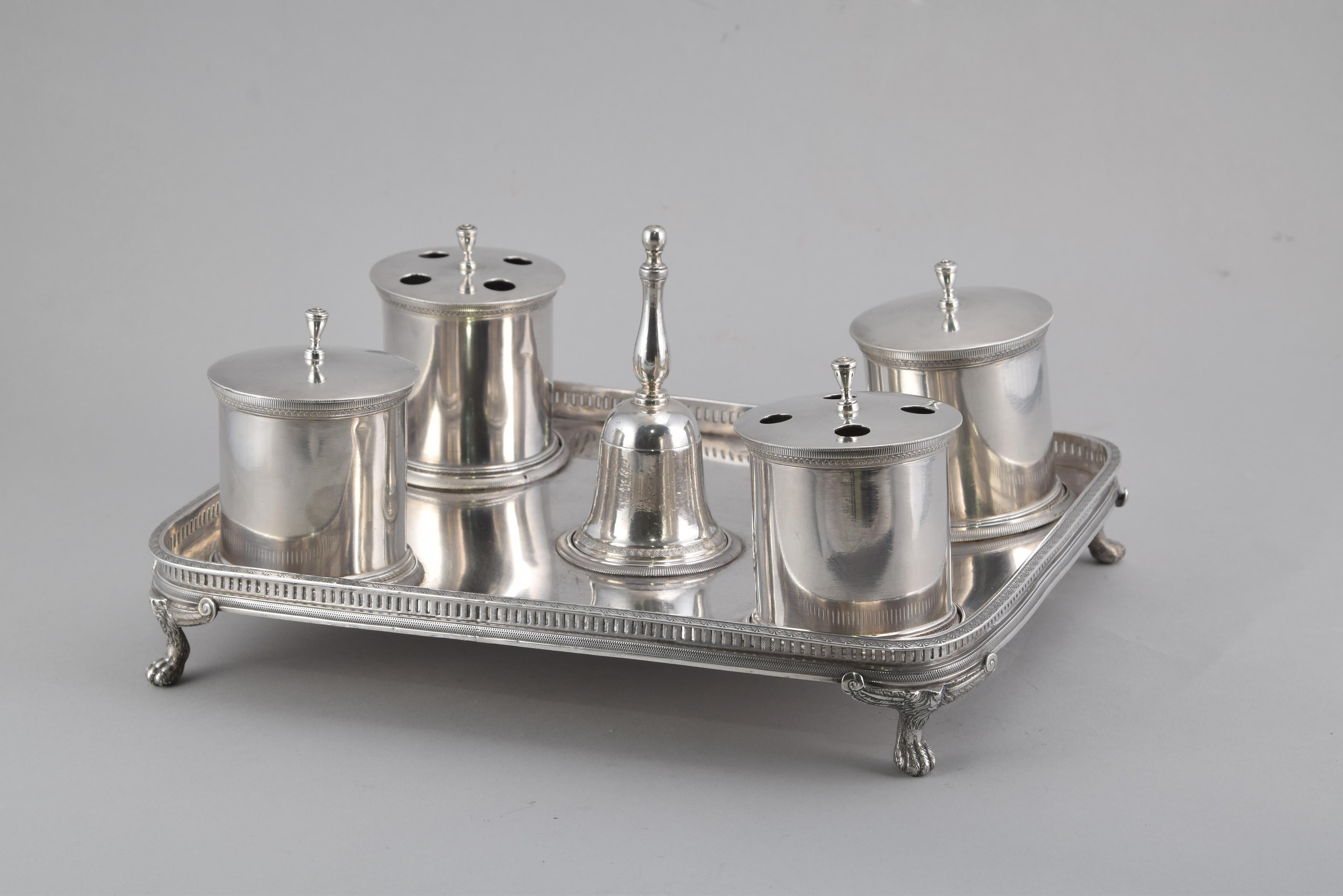 Scribe with four inkwells and bell. Silver. Madrid, Silversmiths Martínez, 1819.
 With contrast marks.
 Notary of silver in its color composed of a rectangular tray (raised on four claw-shaped legs and with smoothed corners), four containers (two