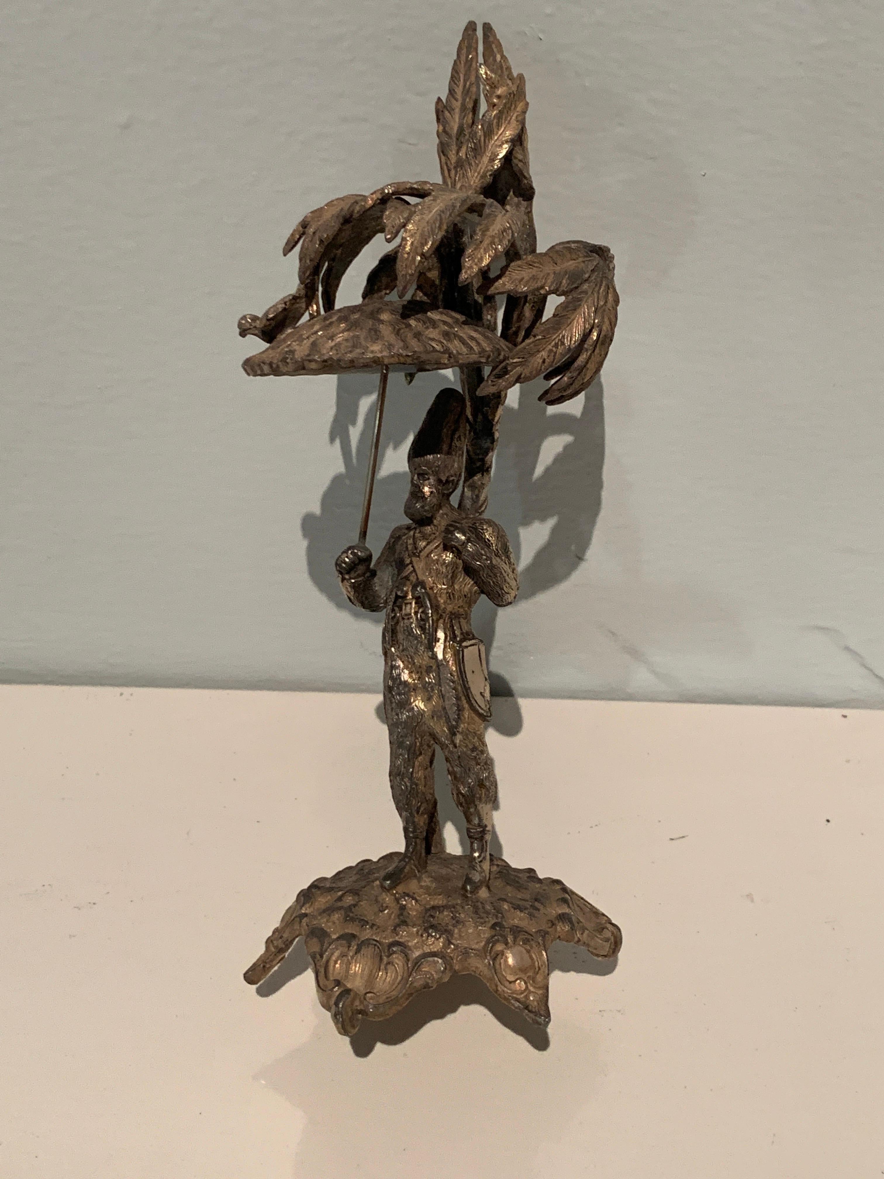 A unique piece - a man, perhaps a jester, holding an umbrella with a bird. The piece would make a nice decorative item or even a paperweight. Folkart decorative.