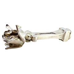 Silver seal w/ flower at the top on a column w/ a square base
coat of arms