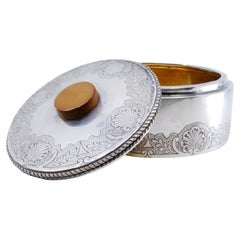 Silver seashell vanity box with a trim on the lid and wooden handle