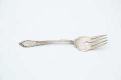 Silver serving fork with four prongs and reliefs