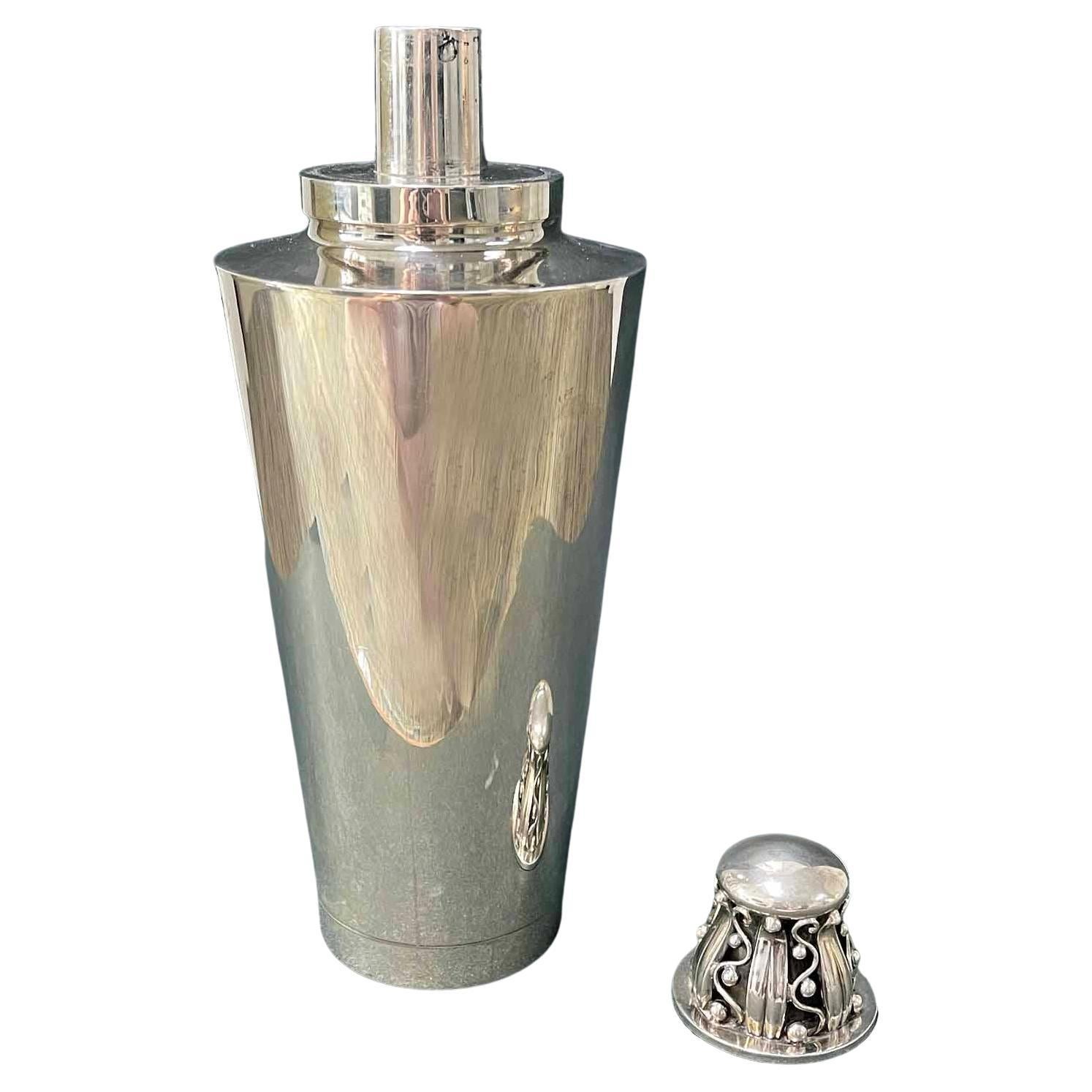 A unique and exceptional example of fine Art Deco silver artisanry, this sterling cocktail shaker by Evald Nielsen is surmounted by a domed cap with a vine-and-leaf motif. The sloping body of the shaker is elegant and streamlined, contrasting with