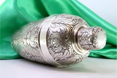Silver shaker with revealed floral motifs and beading on the lid