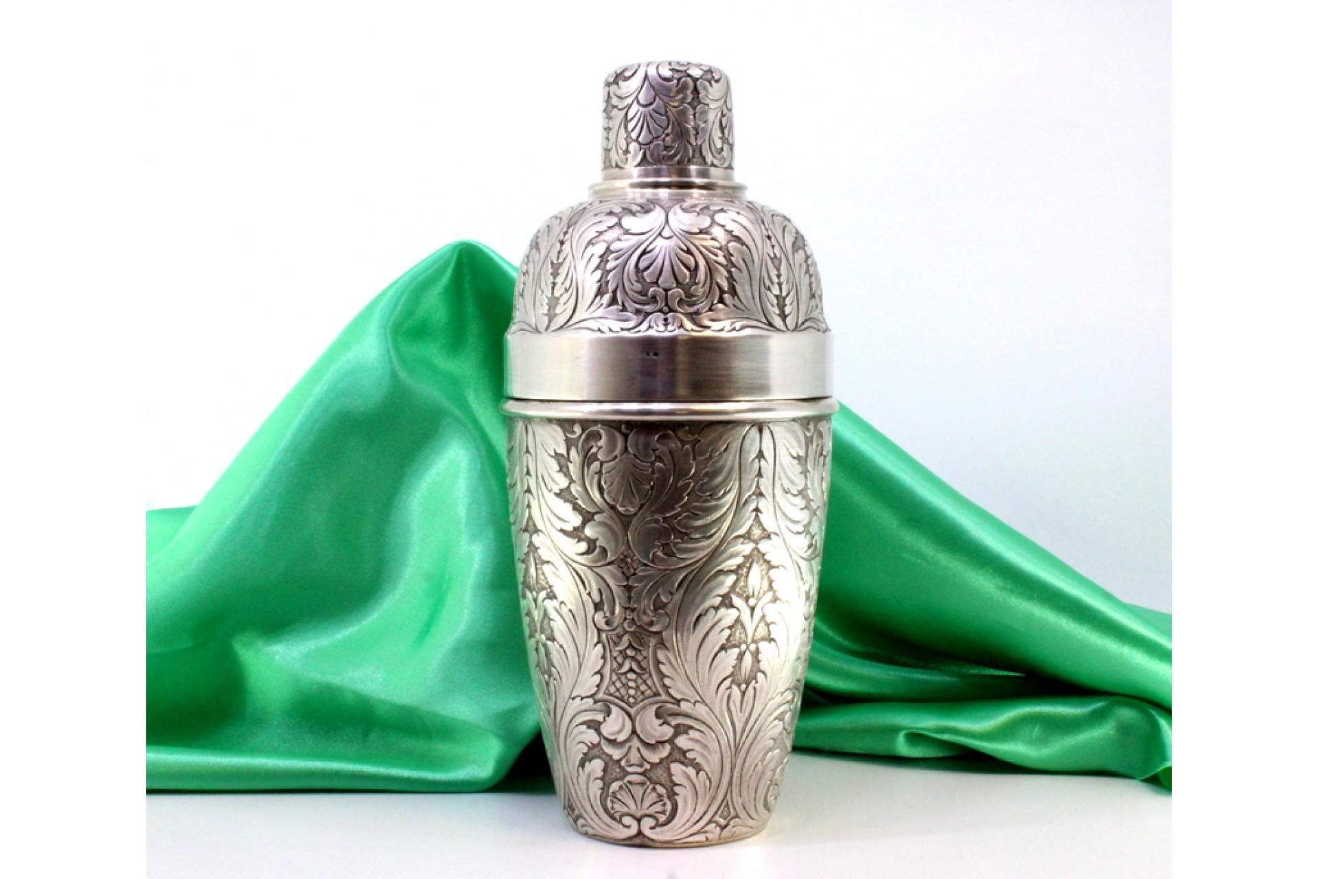 Silver shaker with revealed floral motifs and beading on the lid