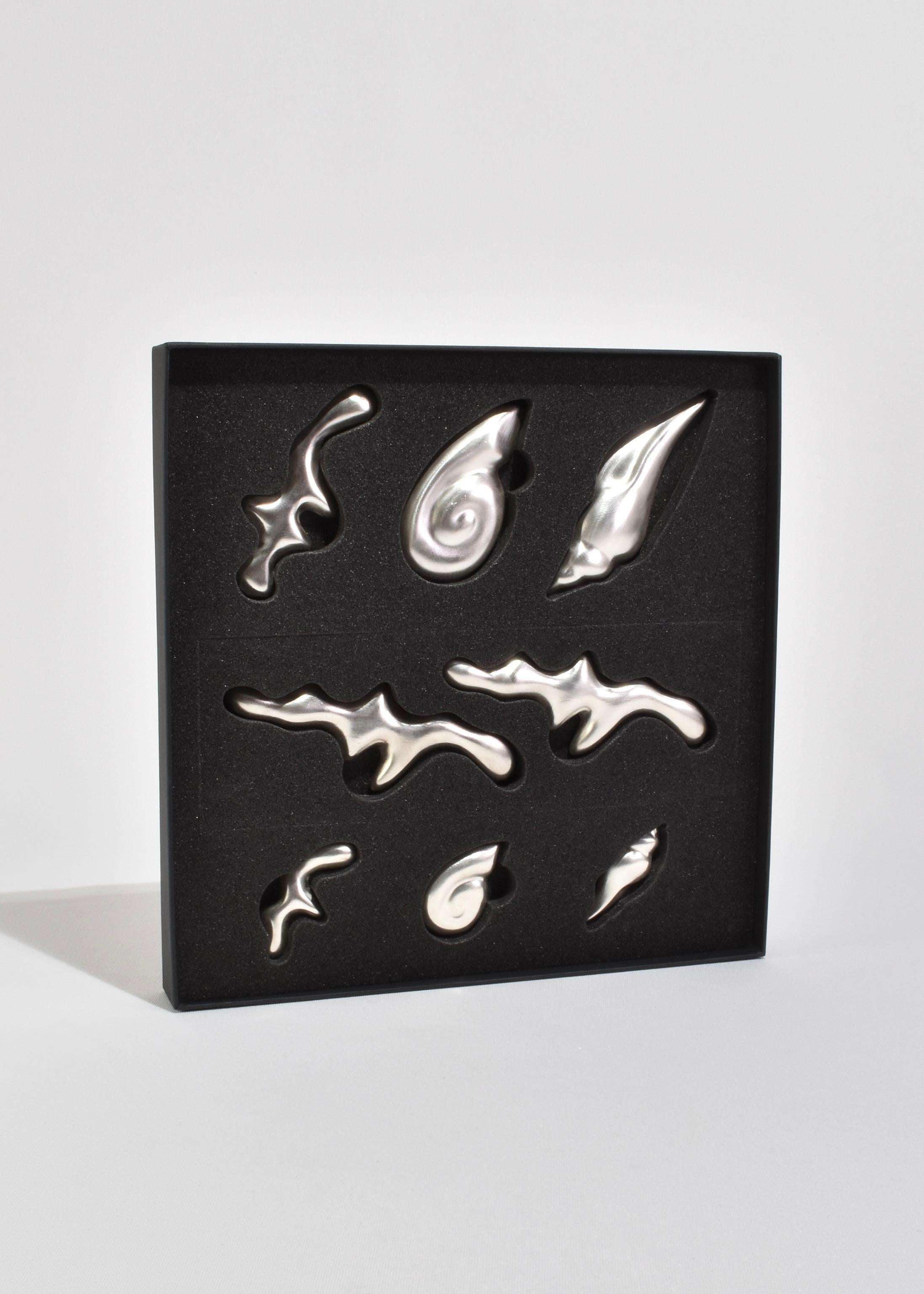 Wunderschönes Geschenkset mit Muschelbesteck aus Keramik in Silberglasur. Das Set enthält acht Muschelauflagen in verschiedenen Formen und Größen, verpackt in einer Geschenkbox.

Von IAAC Crafts Keramik Studio, handgefertigt in