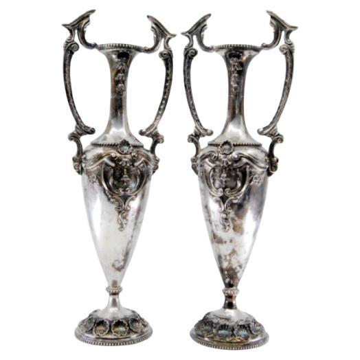 Silver shell-shaped jugs with pearly floral motifs on the base and necks