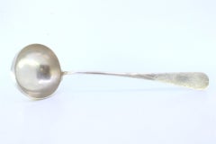 Silver shell-shaped ladle with engraved monogram cartouche
