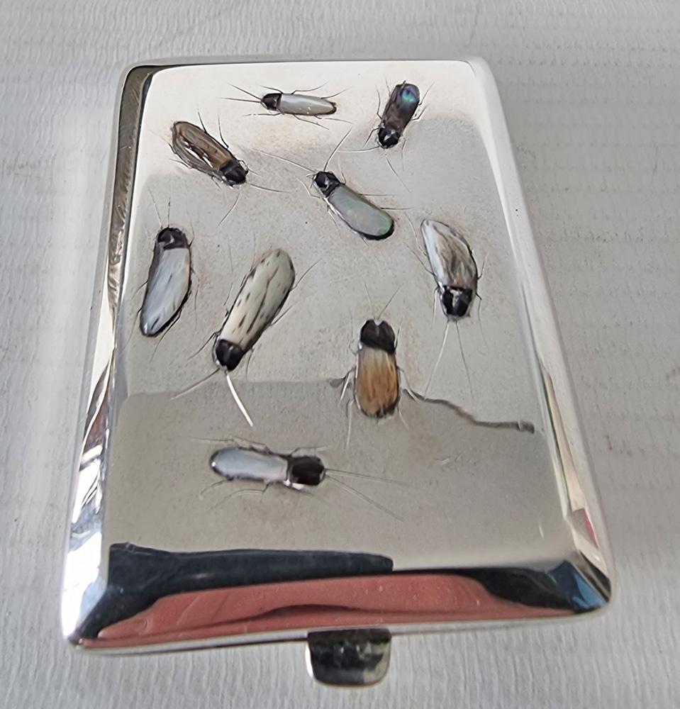 Un raffinato e raro portasigarette o porta fiammiferi Shibayama in argento. Punzoni d'argento di Birmingham 1925 e marchio del produttore Henry Williamson Ltd. La cassa presenta 9 insetti intagliati a mano in pietre semipreziose dall'artigiano.  La