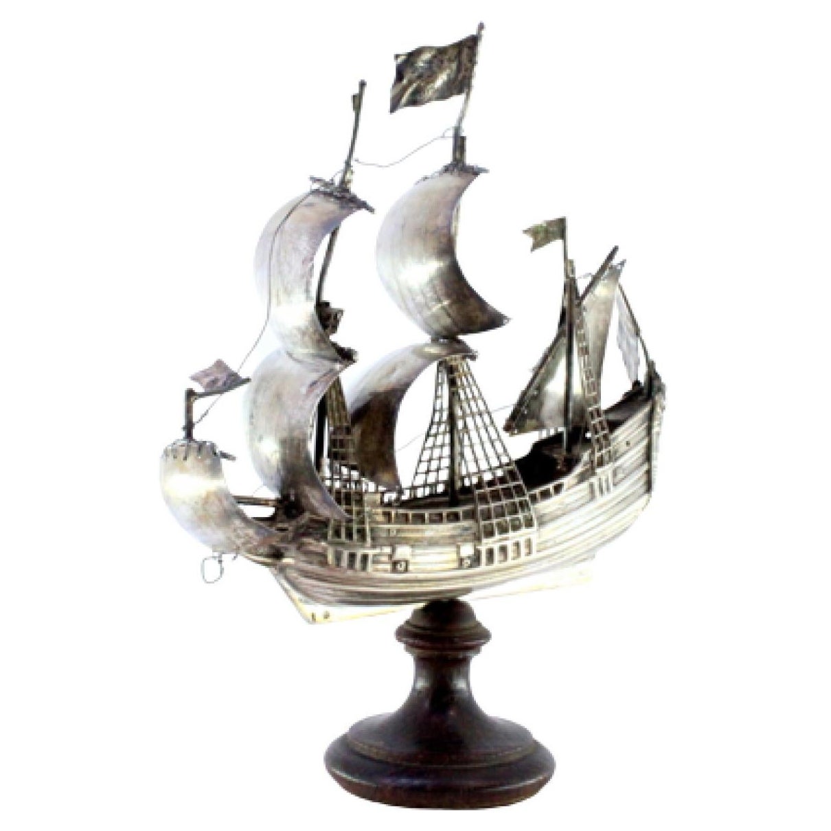 Silver ship with masts and sails, resting on a wooden base