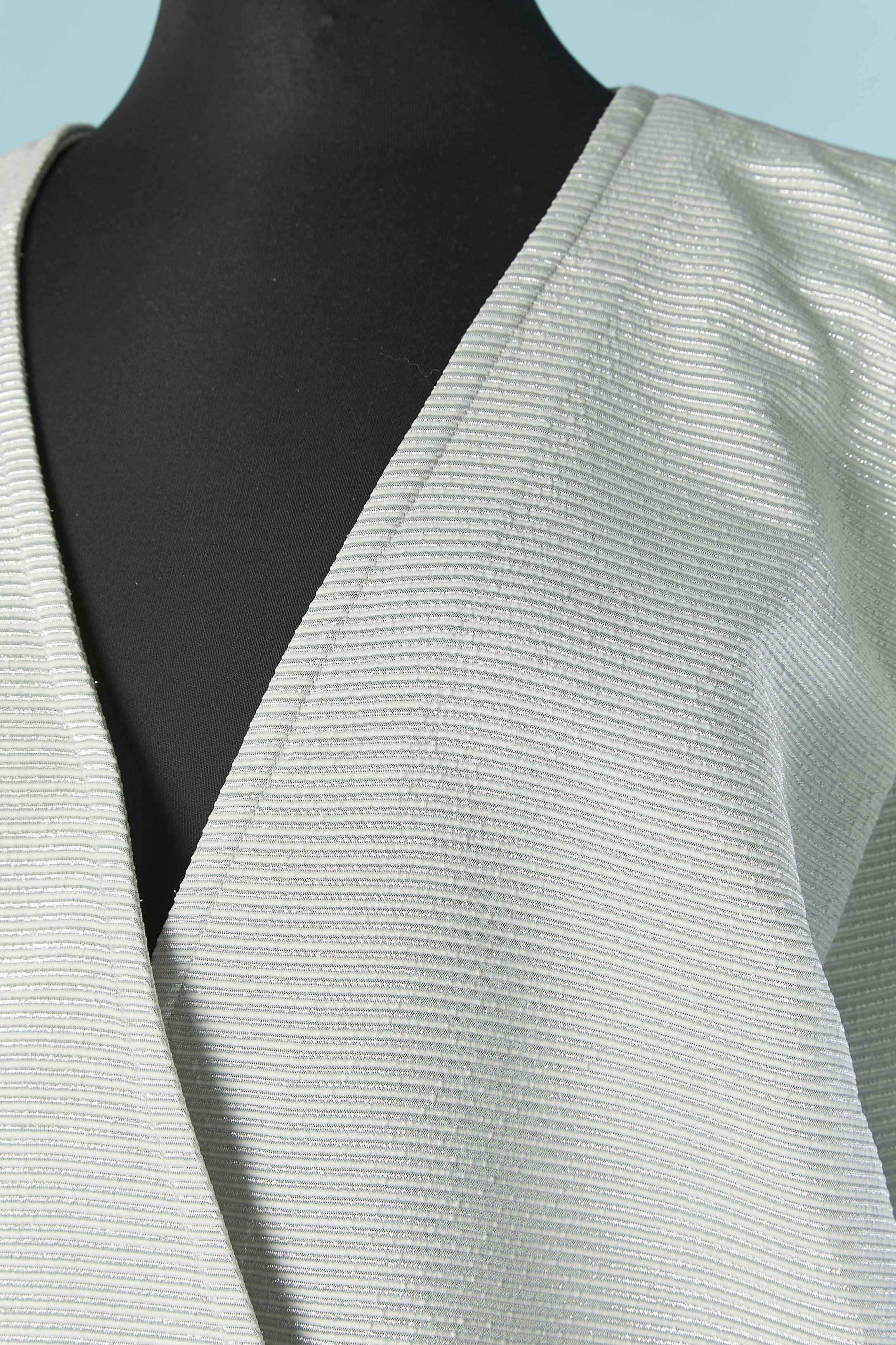 Silver skirt suit with double breasted jacket. Main fabric composition: 52% polyester, 48% rayon. Lining: 100% acetate. 
Button and buttonhole closure on the middle front. Gather on the top of the sleeve around the sleeve head.Pocket on both side on
